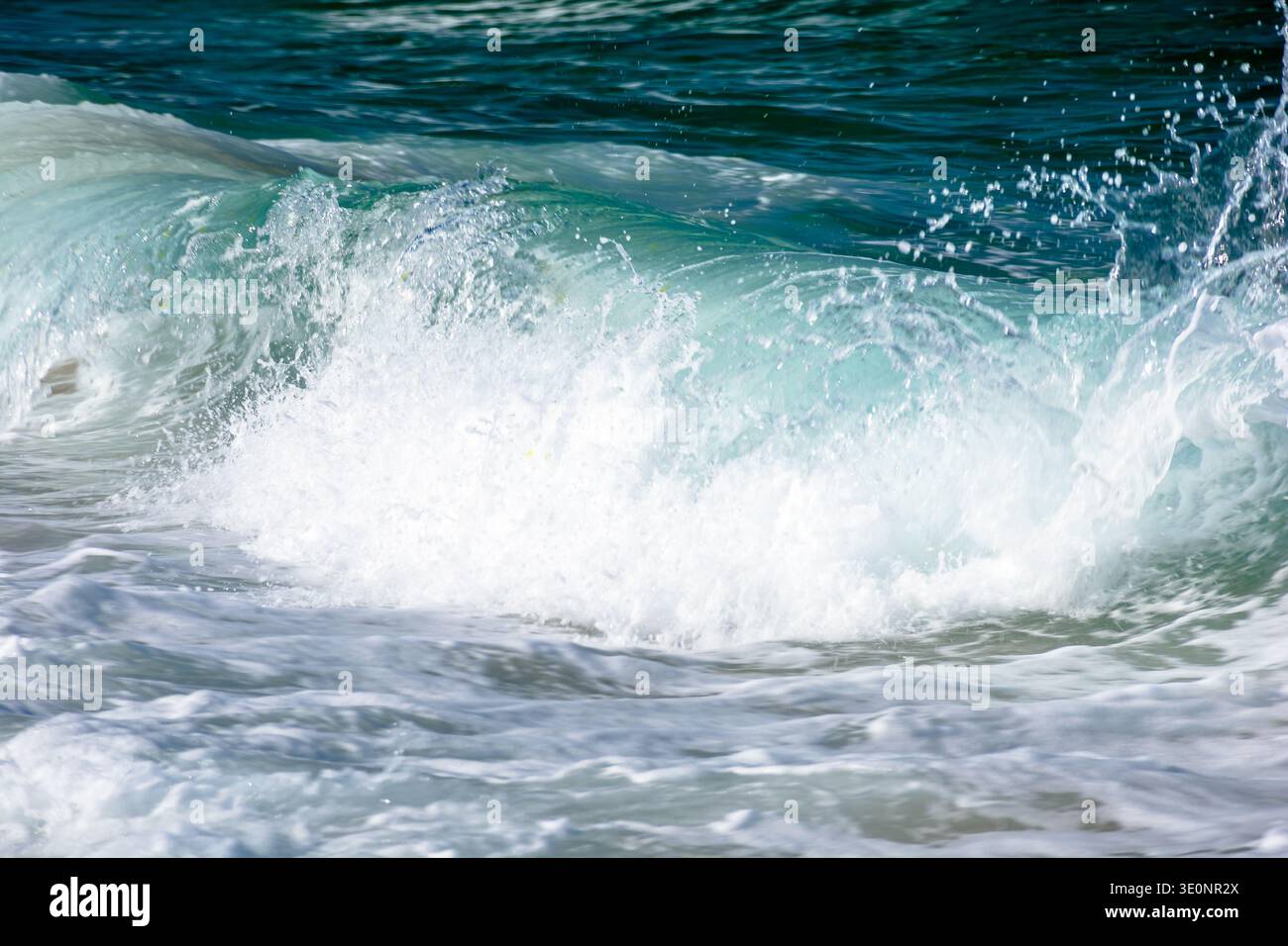dynamic wave crashes sandy beach in afternoon. telephoto closeup shot for calendar or card backdrop. pristine place of zosopol waterfront in bulgaria. Stock Photo