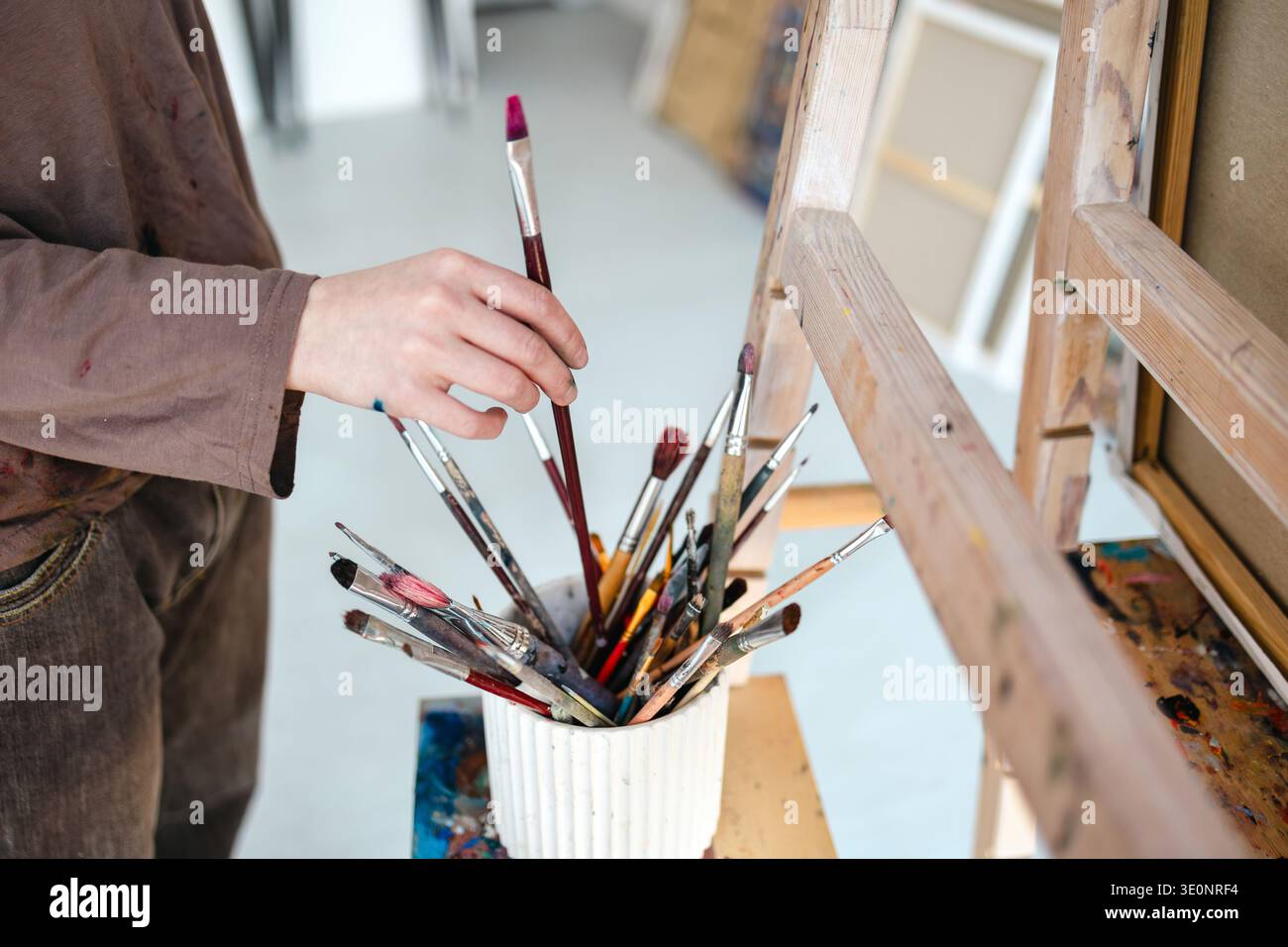 Close-up of a painter's hand holding a paintbrush in her studio Stock Photo