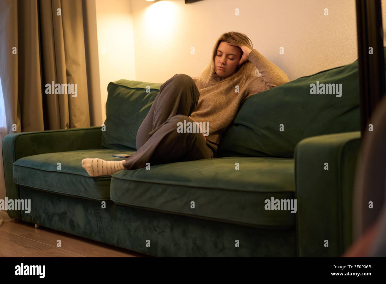 Resting on a Green Sofa in Soft Evening Light Stock Photo