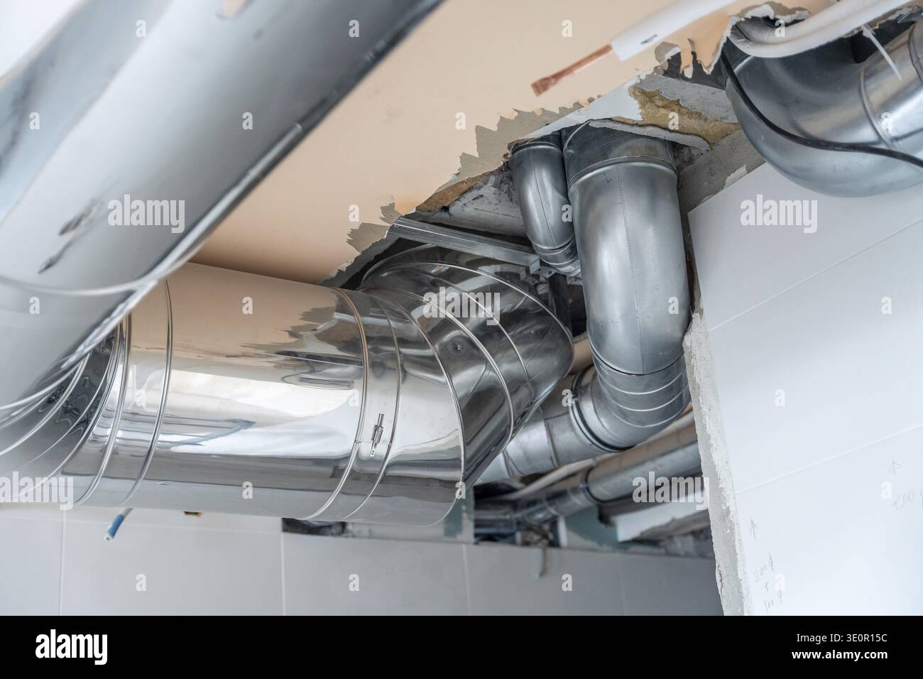 Exposed metal ventilation ducts and pipes connecting a new air ...