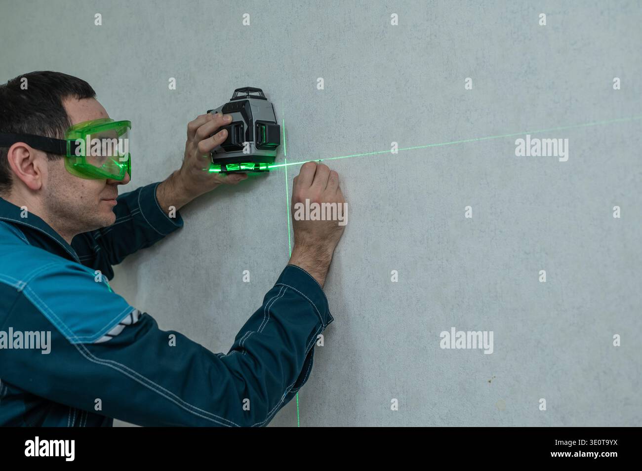 A man measures distance with a laser level.  Stock Photo