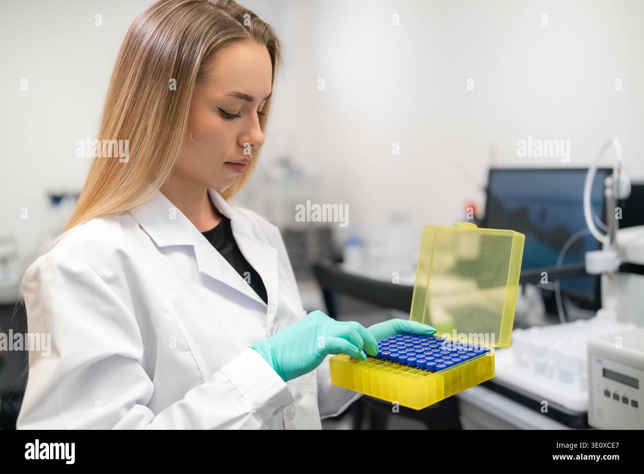 Scientist checks HPLC vials in yellow storage box at pharmaceutical ...