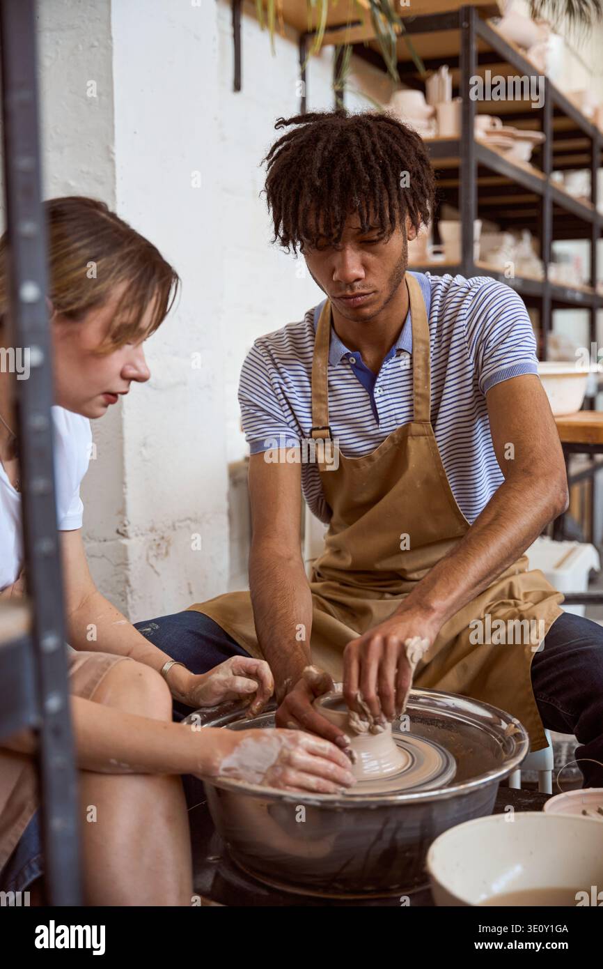 Young adults creating pottery in a calm studio environment Stock Photo