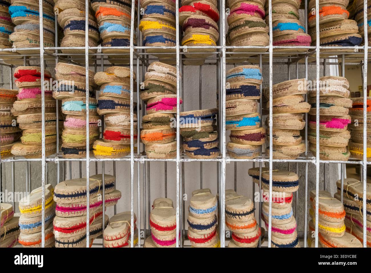 Rows of traditional colorful Spanish espadrilles on a metal rack Stock Photo