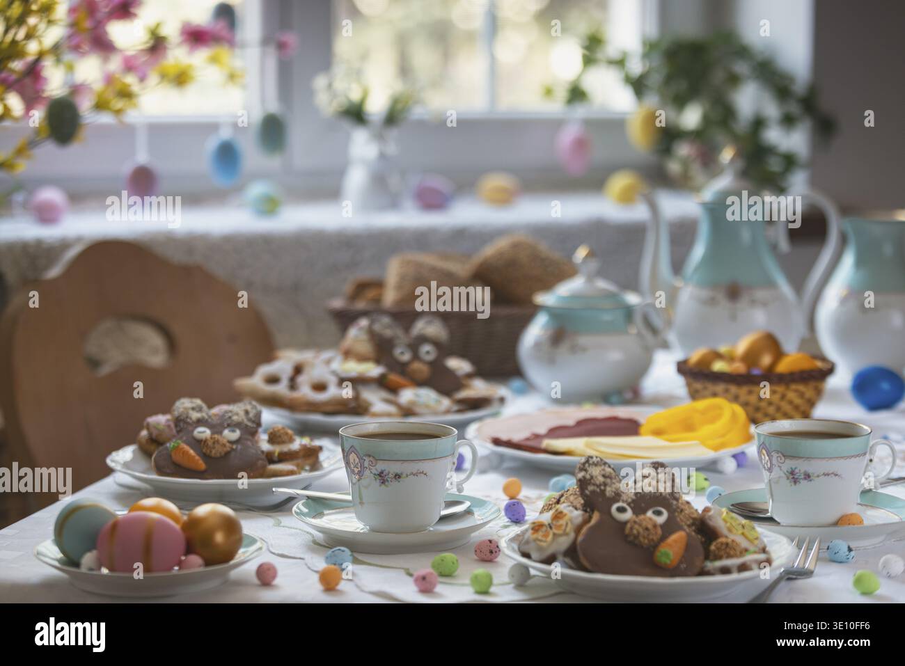 Table set with Easter cookies and coffee, decorated like spring Stock Photo