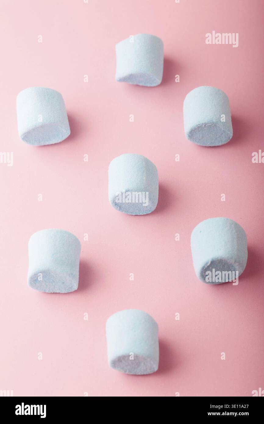 Pattern of blue marshmallows on plain pink background Stock Photo