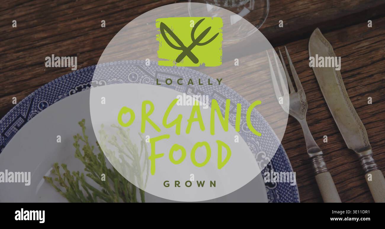 Featuring centered ORGANIC FOOD label on wooden tabletop with charger plate herbs fork, knife Stock Photo