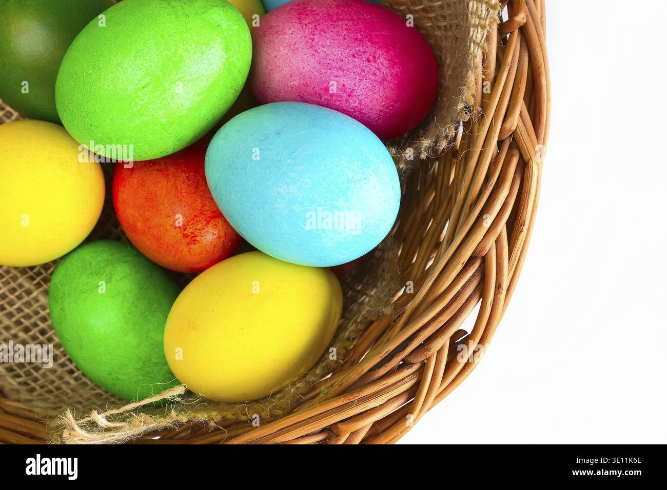 Brightly colored closeup easter eggs in basket, holiday background Stock Photo