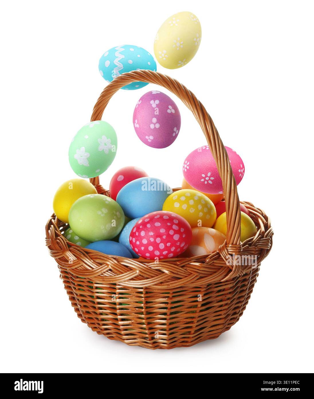 Bright Easter eggs falling into basket on white background Stock Photo