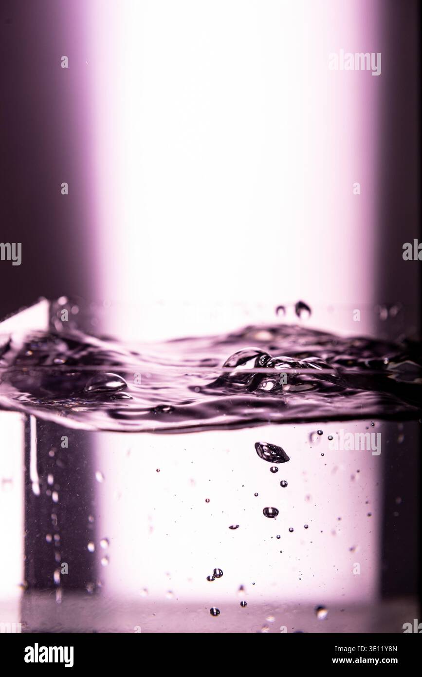 420.droplet colliding with a liquid surface, creating a small, detailed ...