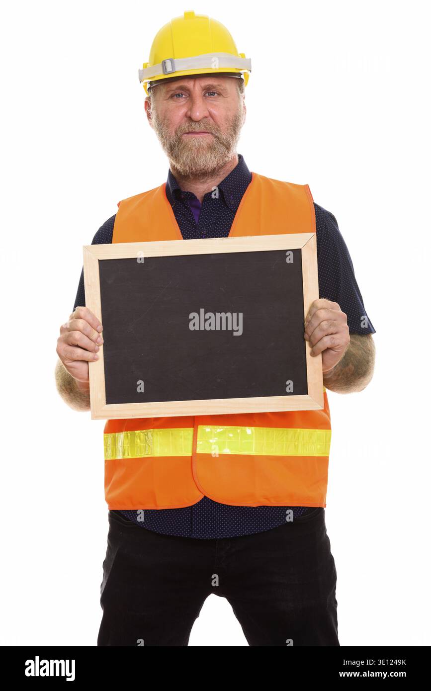 Mature bearded man construction worker holding blank blackboard Stock Photo
