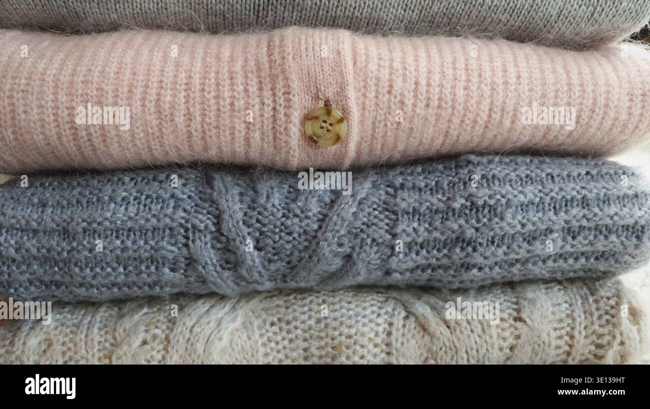 Stack of warm cozy knitted women's sweaters . Autumn or winter comfort concept Stock Photo
