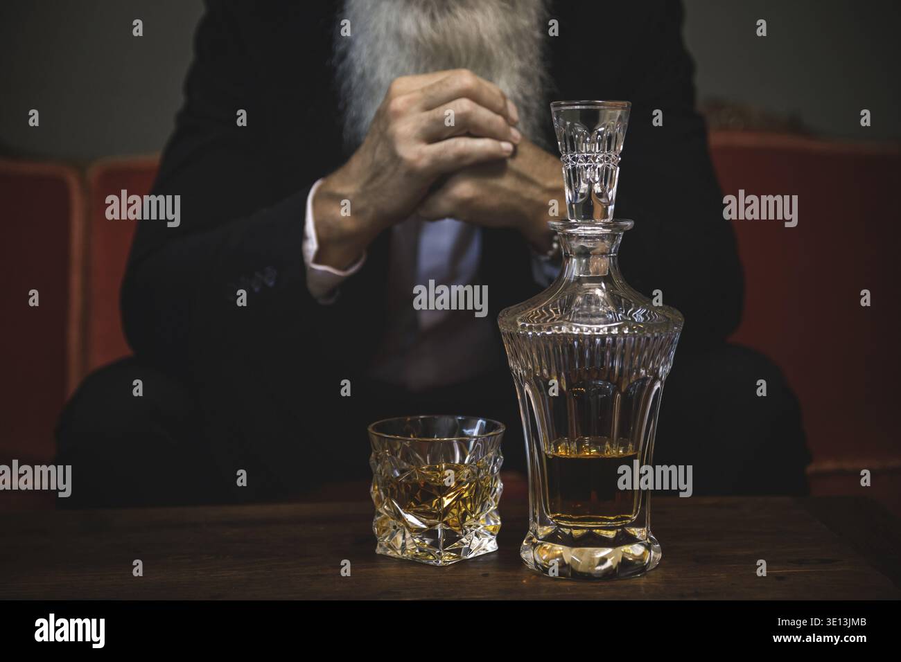 Stylish and handsome bearded senior man drinking whiskey Stock Photo