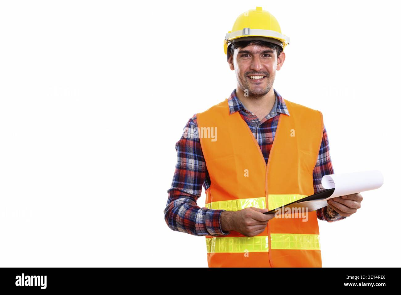 Young happy Persian man construction worker smiling while holding clipboard Stock Photo