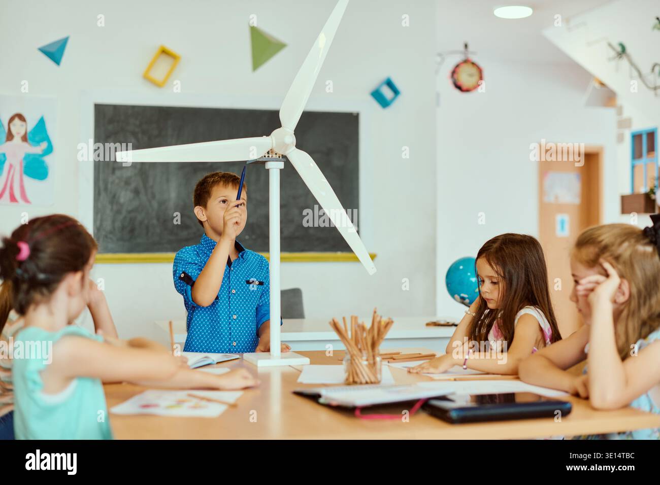 Children exploring a wind turbine model during a hands-on STEM lesson ...