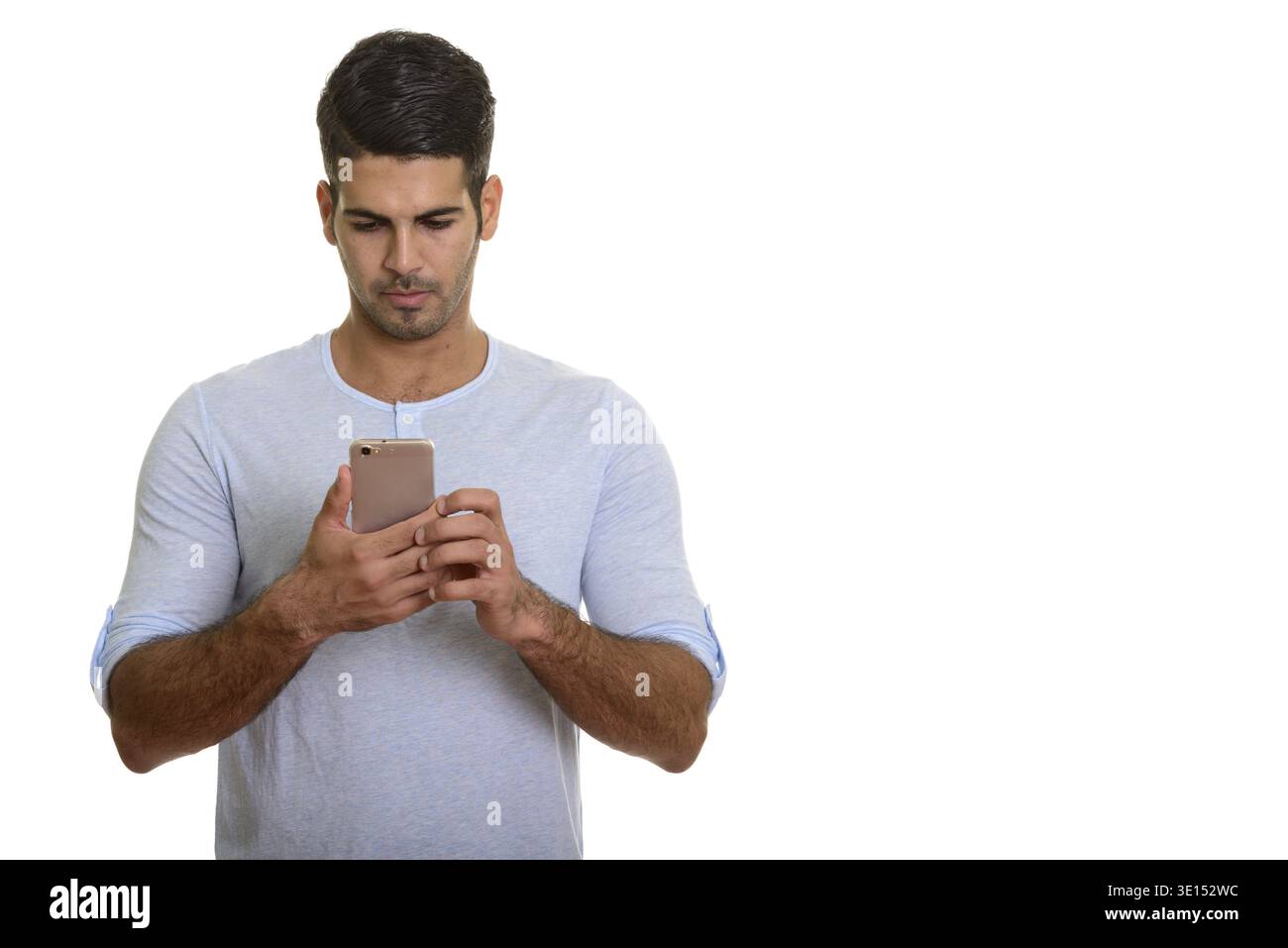 Young handsome Persian man using mobile phone isolated against white background Stock Photo