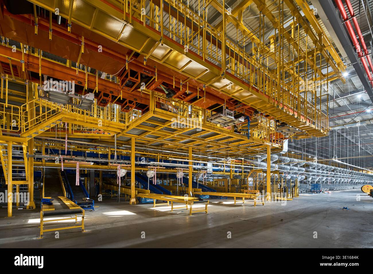 Bright industrial sorting hall with layered conveyors and structural ...