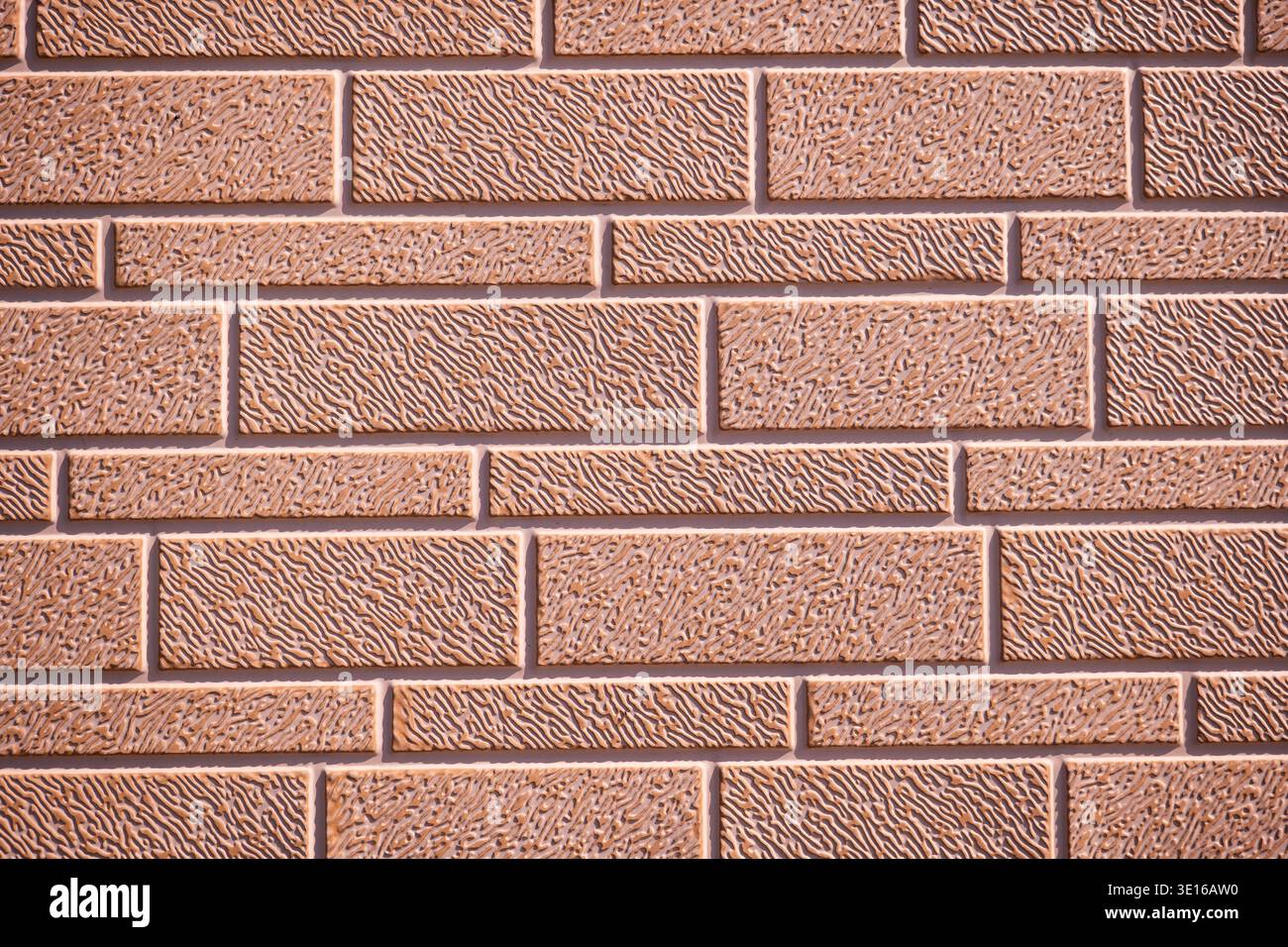 Textured brown brick wall surface creating a repeating pattern and background Stock Photo