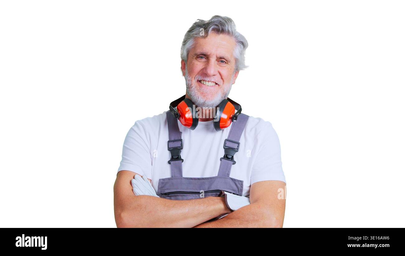 Smiling senior construction worker with safety ear muffs Stock Photo