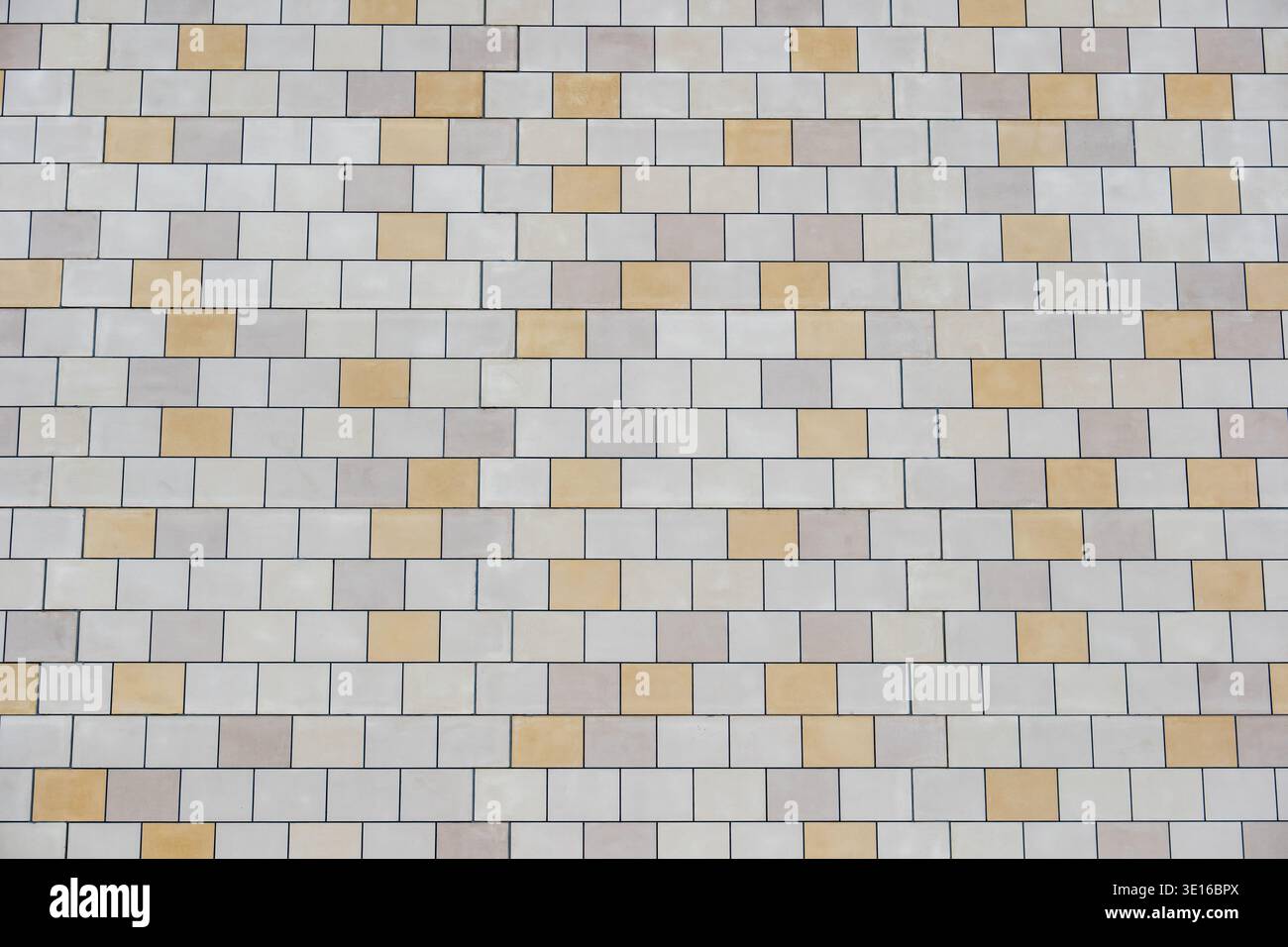 Building facade featuring rectangular stone tiles forming a geometric pattern Stock Photo