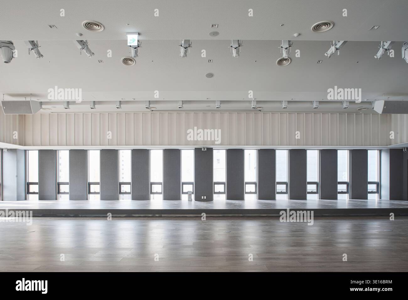 Large empty hall with a rhythmic wall of vertical windows and even ...