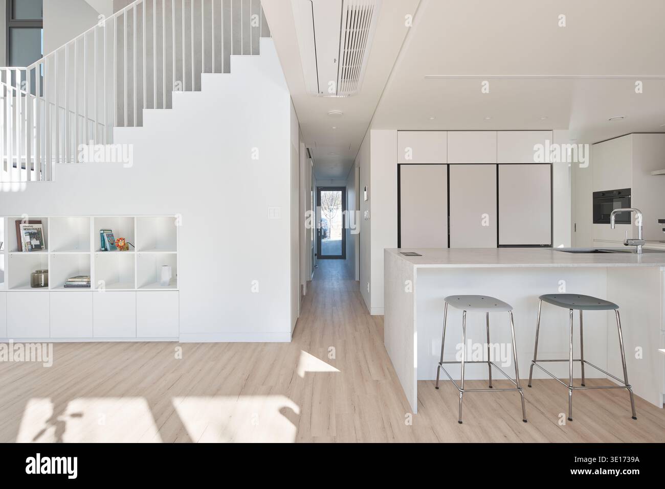 Bright white kitchen and dining space in a minimalist home. Stock Photo