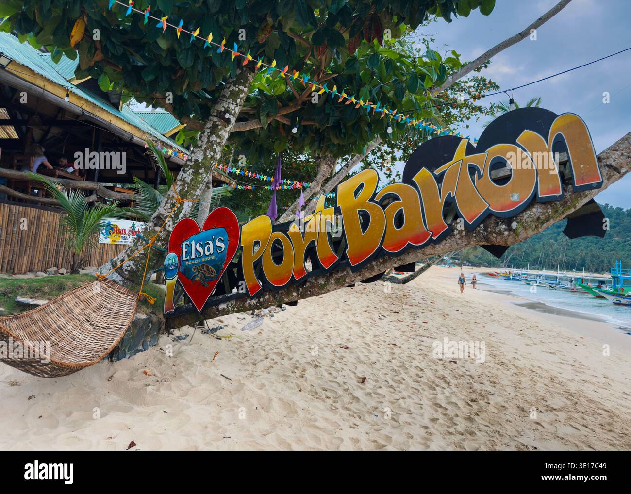 Colourful Port Barton beach sign on Palawan island, Philippines, with tropical shoreline, boats and relaxed seaside atmosphere. - Smartphone Captured Stock Image