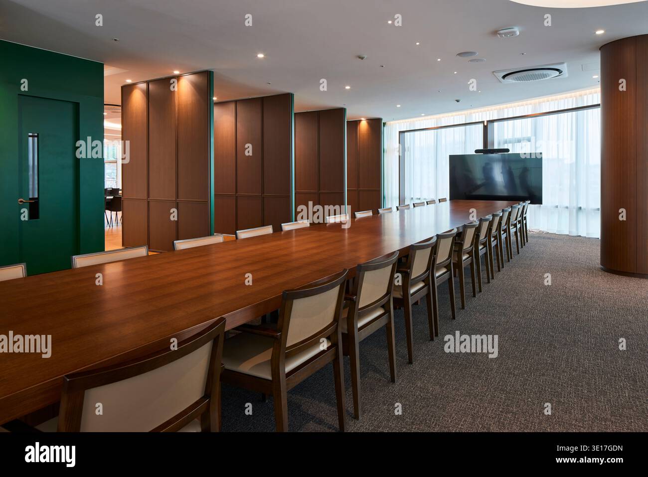 Long conference table in a warm timber lined boardroom. Stock Photo