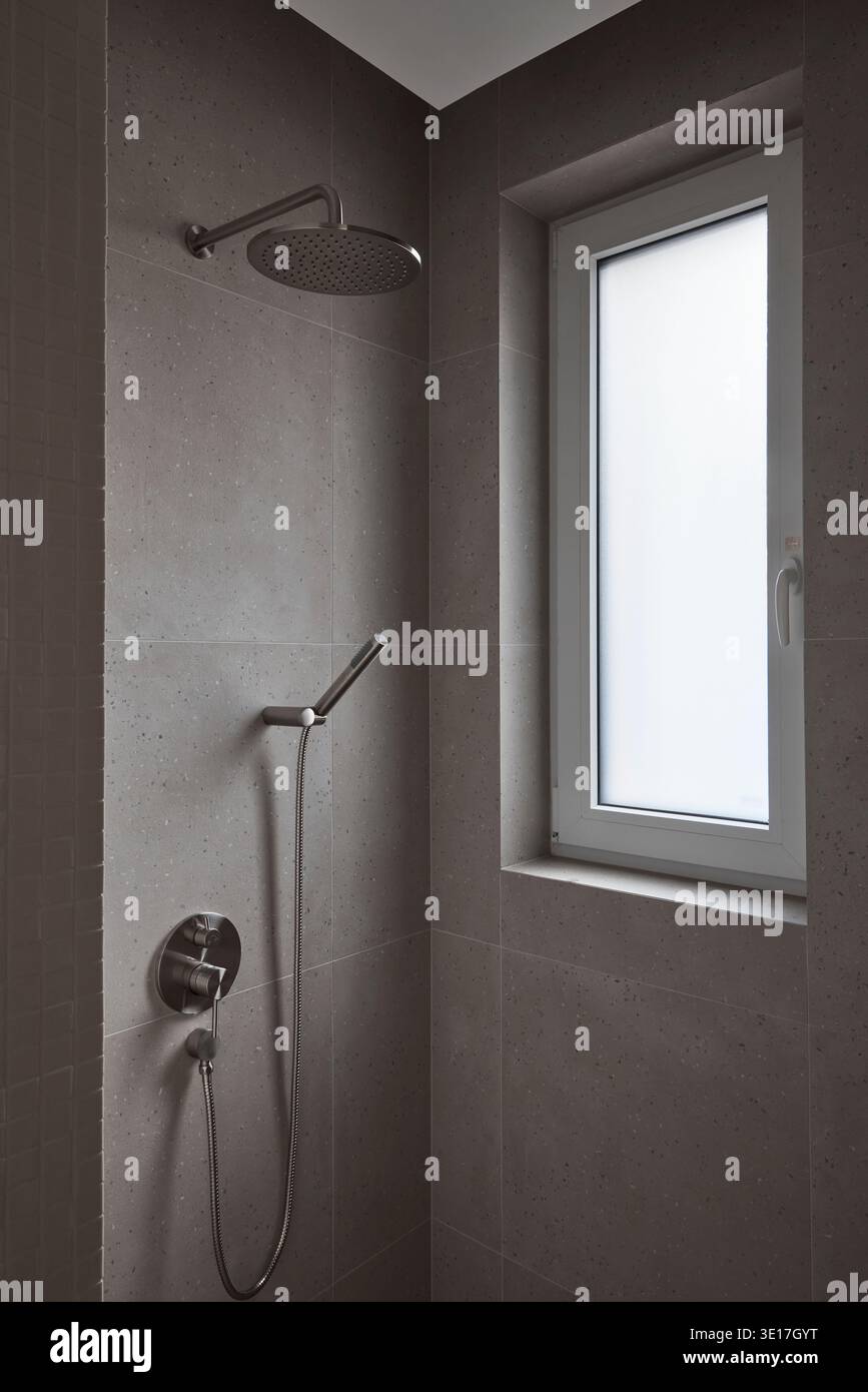 Dark tiled shower room with small window. Stock Photo