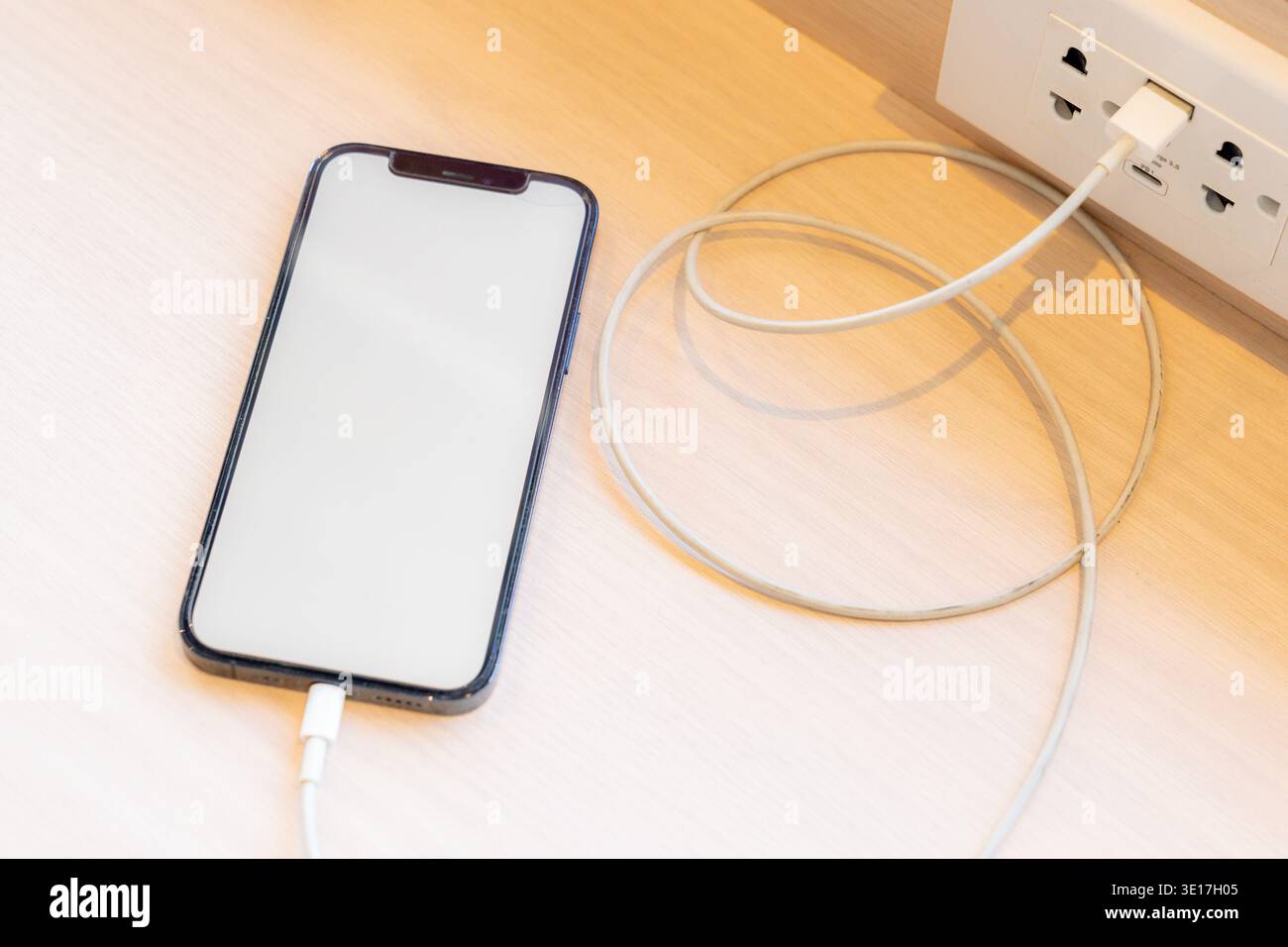 Smartphone charging,plugged into electrical outlet Stock Photo