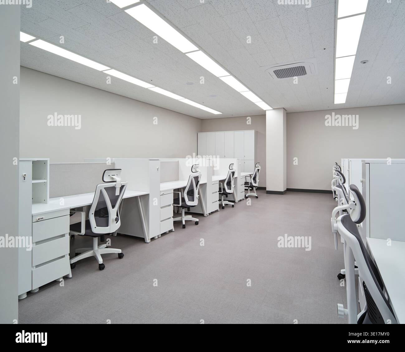 Open office with white workstations and bright daylight. Stock Photo