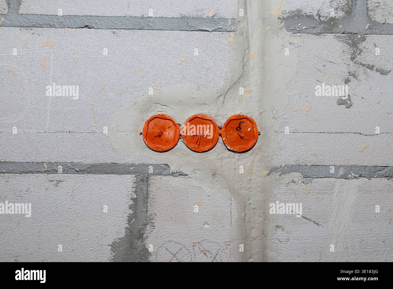 Electrical installation in progress on a white brick wall during house construction Stock Photo