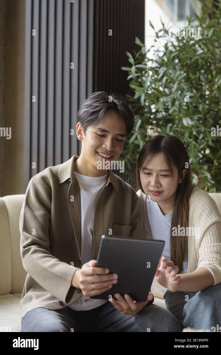 Couple using digital tablet computer in cafe while having coffee Stock Photo