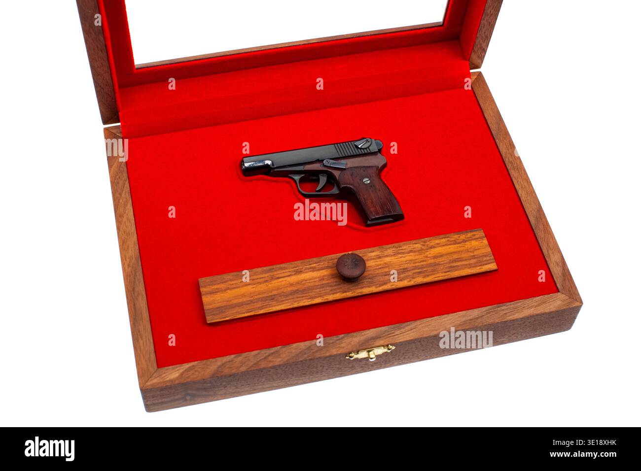 Open wooden display case featuring a miniature pistol model on a vibrant red velvet background. Stock Photo