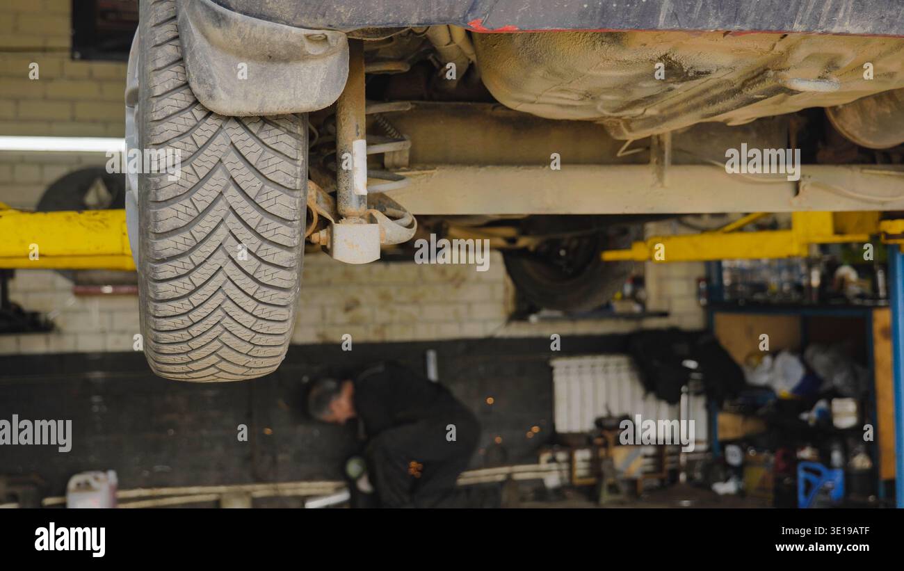 Car lifted on a hydraulic lift during maintenance in a garage Stock ...