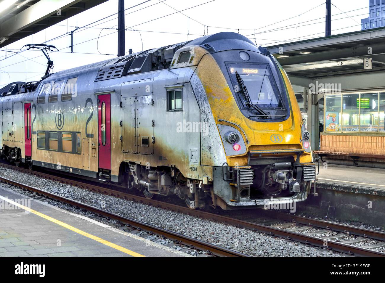 Very dirty, well travelled Belgian Railways Class M7 double-deck / bi-level electric locomotive at Brussels Midi international railway station. Stock Photo