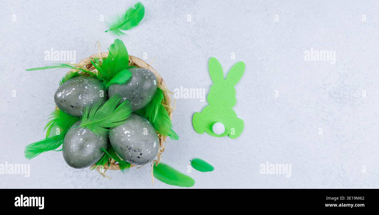 Decorative easter eggs with green feathers and bunny shape Stock Photo