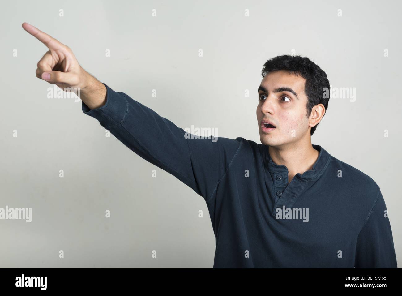 Studio shot of young handsome Indian man against white background Stock Photo