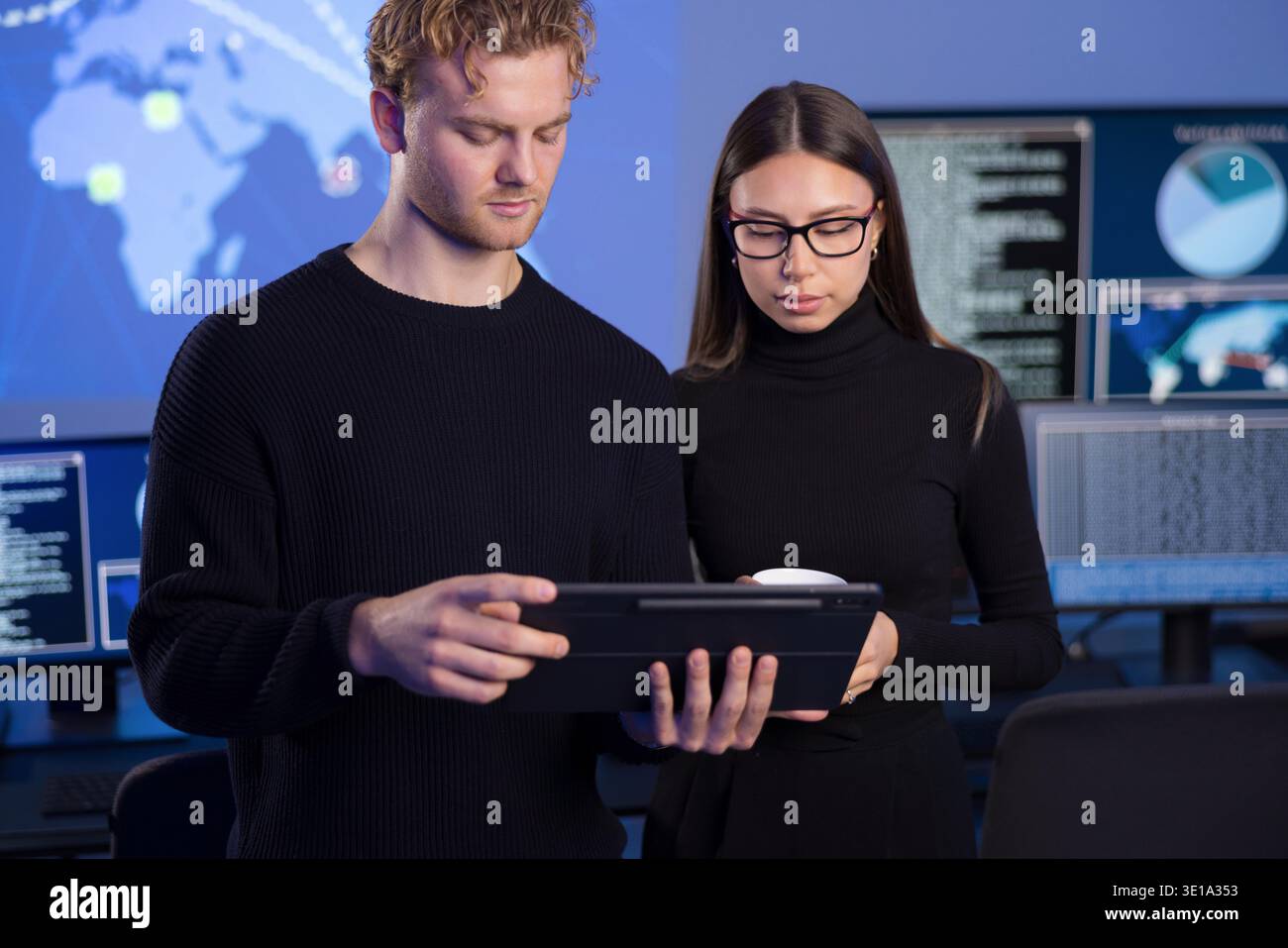 Two cybersecurity professionals analyzing data in a secure operations center Stock Photo