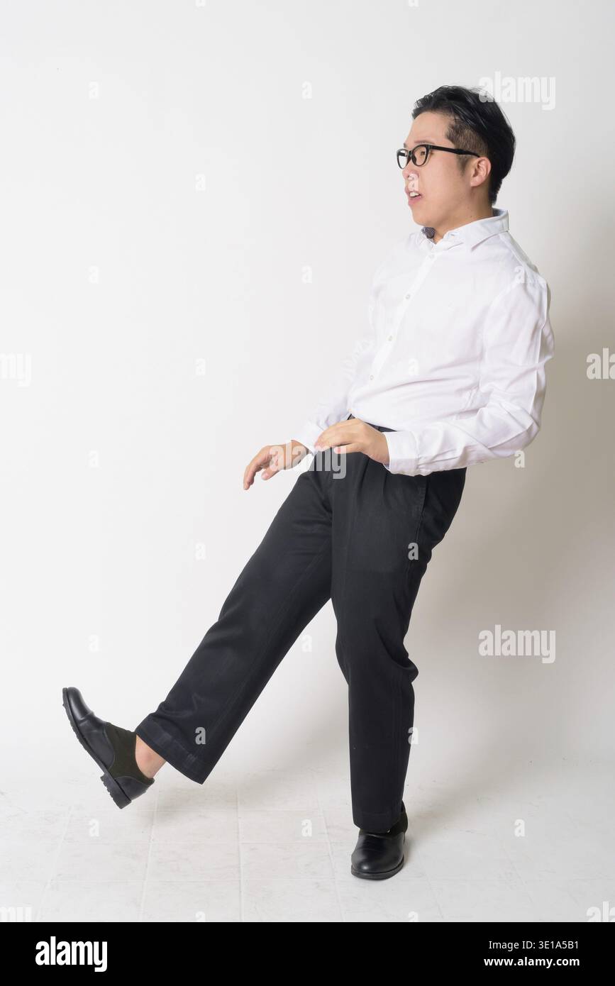 Studio shot of young Asian businessman with eyeglasses against white background Stock Photo