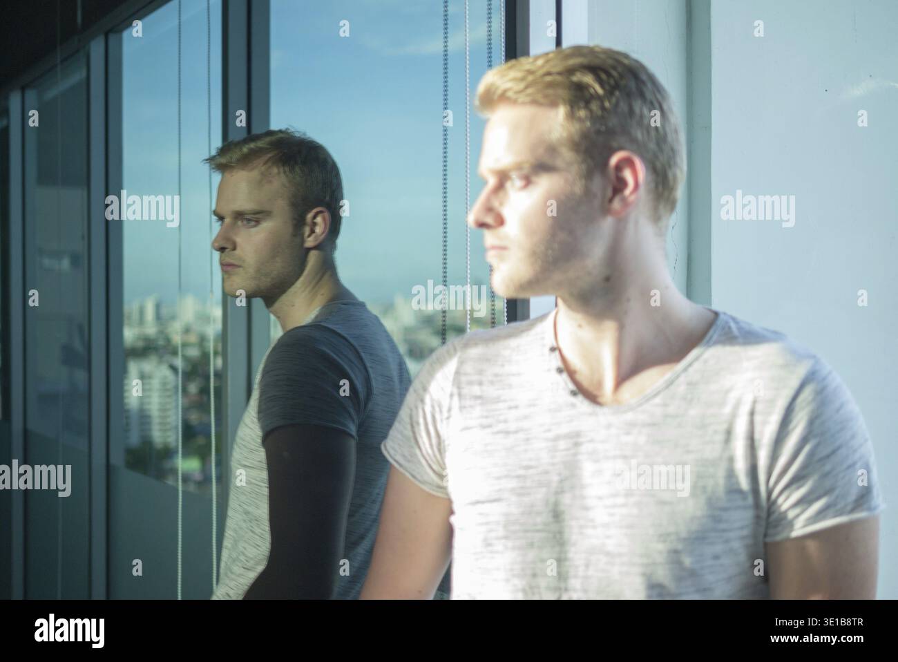 Portrait of young handsome man with blond hair in the city outdoors Stock Photo