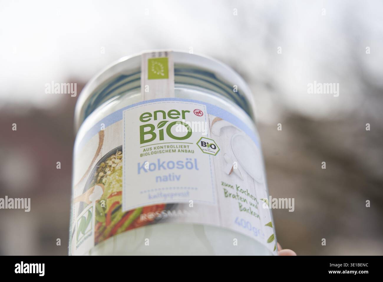 Glass with EnerBio virgin coconut oil held in one hand, blurred background, Ener Bio, organic, by Rossmann Stock Photo