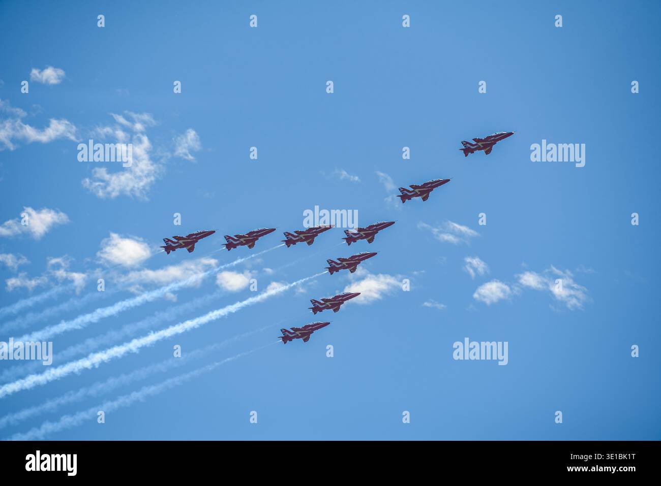 A group of aerobatic jet aircraft flying in perfect formation during an airshow, leaving smoke trails against a clear blue sky during Nato days in Cze Stock Photo