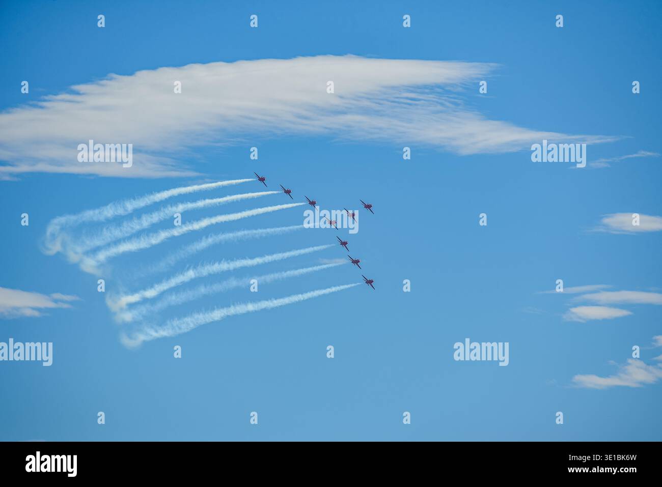 A group of aerobatic jet aircraft flying in perfect formation during an airshow, leaving smoke trails against a clear blue sky during Nato days in Cze Stock Photo