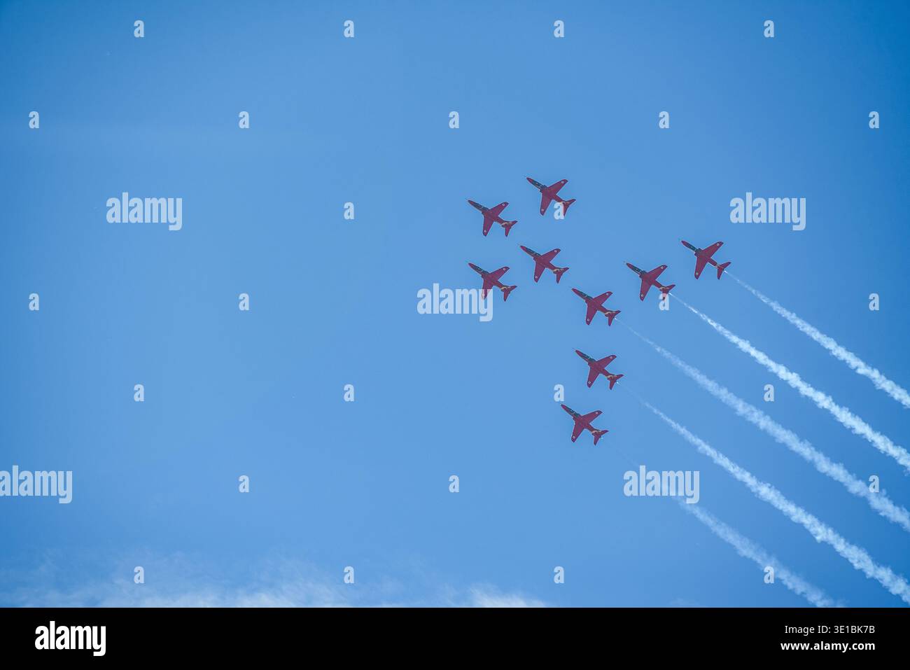 A group of aerobatic jet aircraft flying in perfect formation during an airshow, leaving smoke trails against a clear blue sky during Nato days in Cze Stock Photo