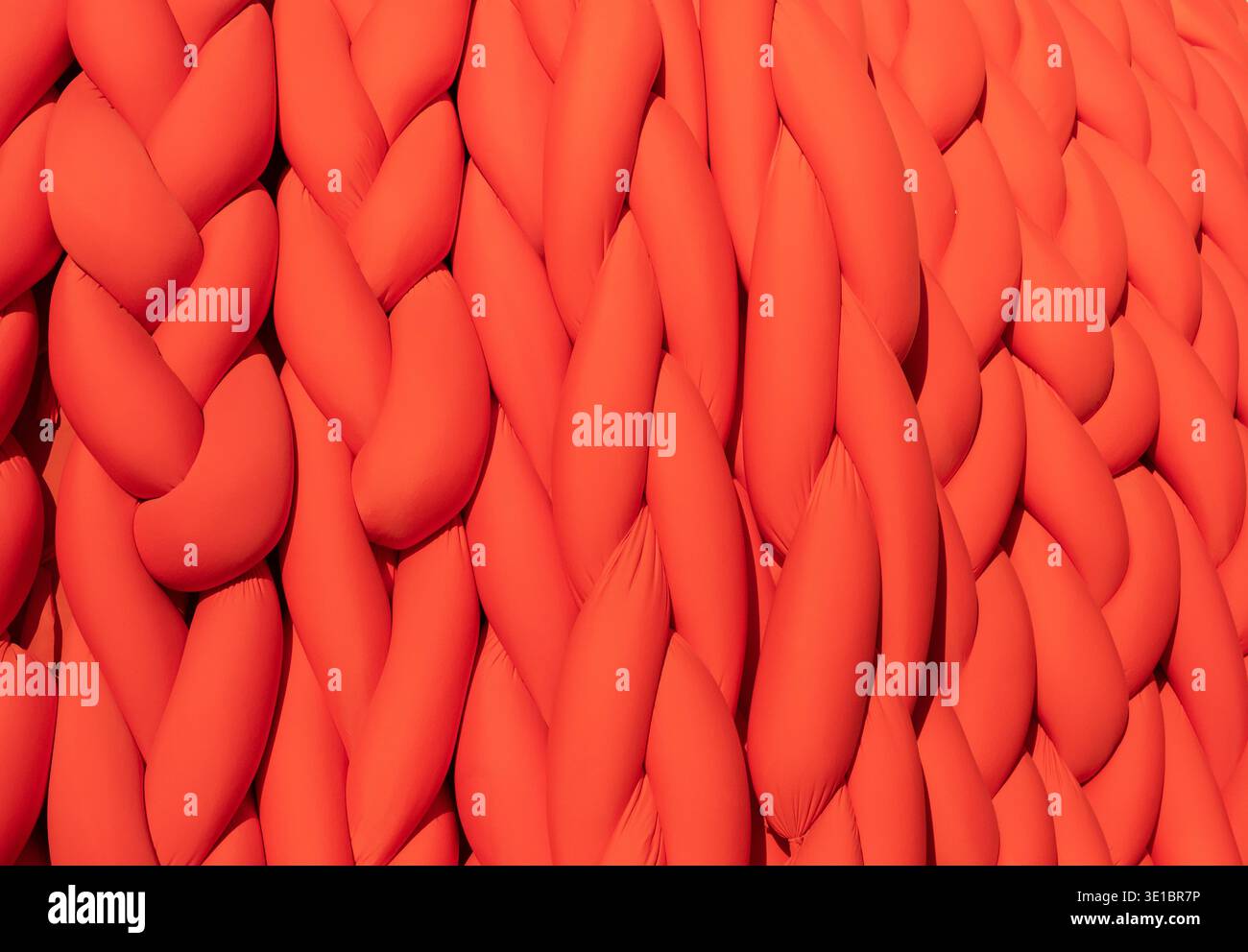 Abstract orange braided fabric creating a vibrant pattern and soft textile background Stock Photo