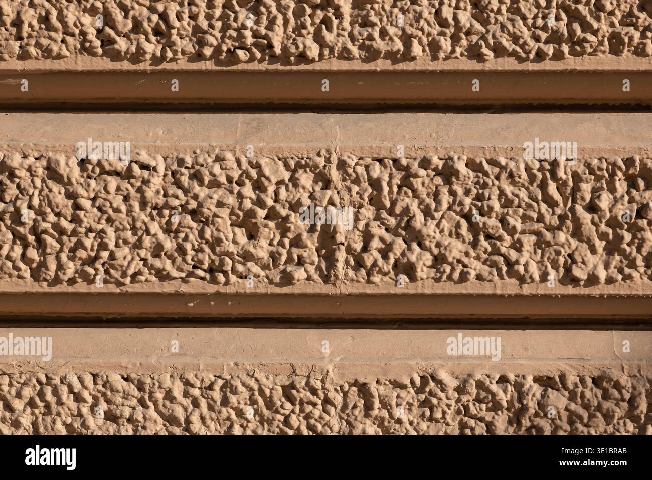 Rough texture wall with horizontal plaster bands creating a detailed pattern Stock Photo