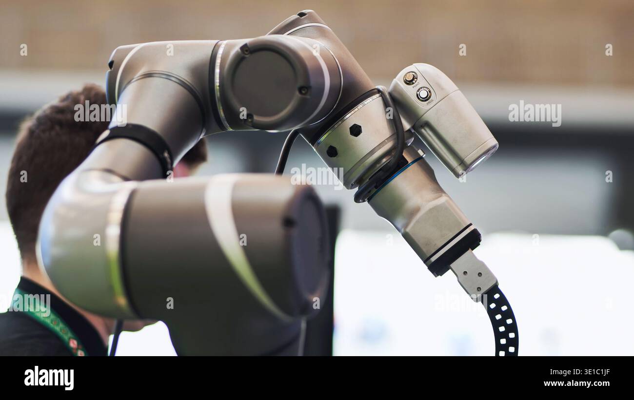 Robotic arm collaborating with human operator demonstrating automation technology Stock Photo