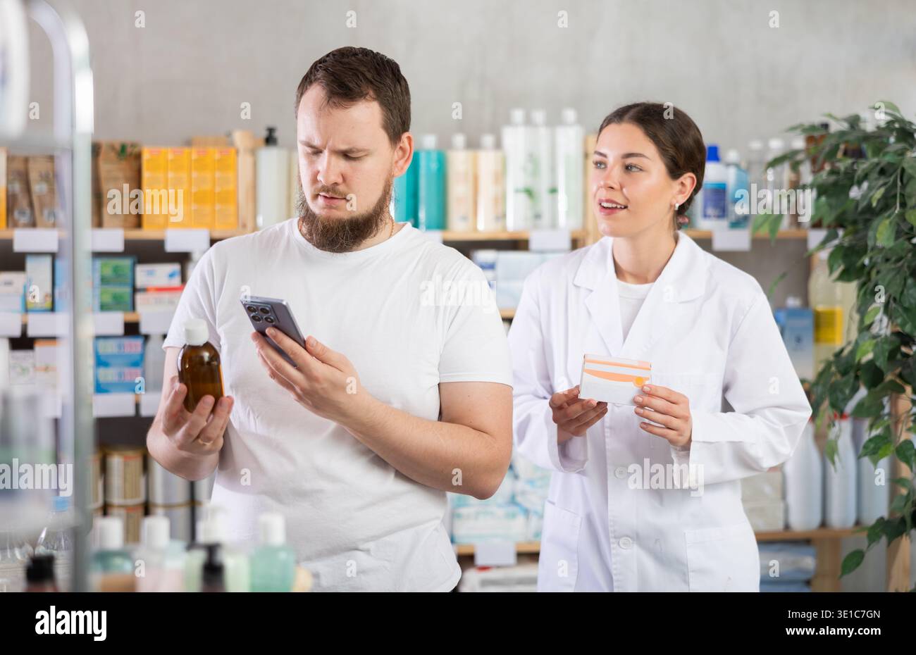 Man buyer scans syrup qr code with woman pharmacist Stock Photo