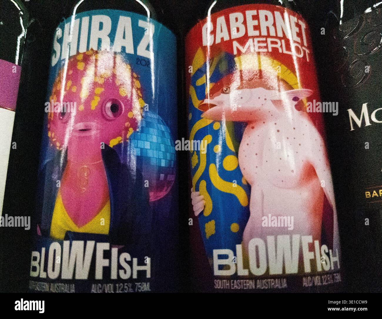 bottles of Blowfish Australian wine display vibrant, character-driven labels for their Shiraz and Cabernet Merlot varieties, on a supermarket shelf Stock Photo